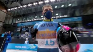 2022 Beijing Olympics - Skeleton - National Sliding Centre, Yanqing District, Beijing, China - February 11, 2022. Vladyslav Heraskevych of Ukraine holds a sign with a message reading 'No war in Ukraine'. IOC/OBS/Handout via Reuters