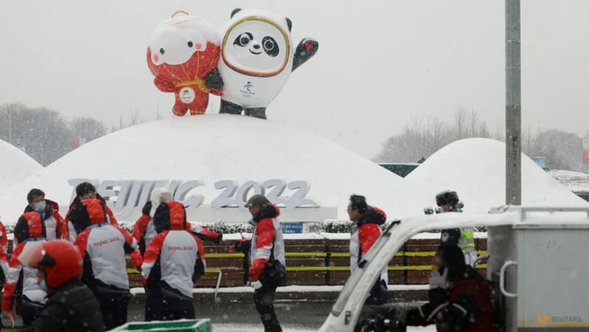 People walk in the snow near the Beijing 2022 Winter Olympics mascot Bing Dwen Dwen and Beijing 2022 Paralympics mascot Shuey Rhon Rhon in Beijing, China, on Feb 13, 2022